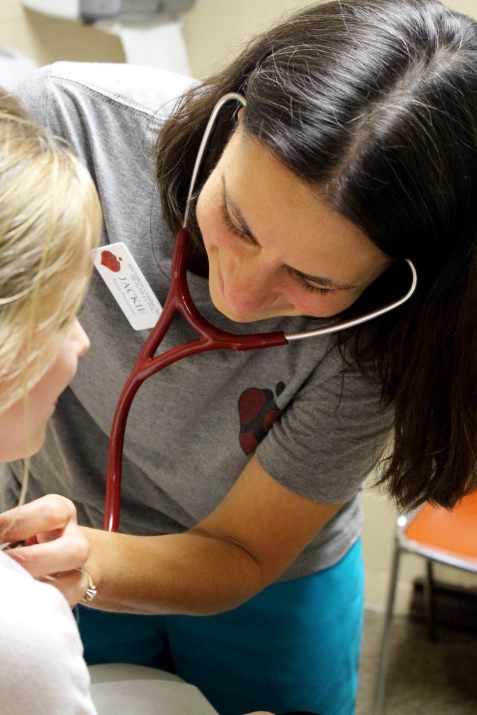 Nurse with stethoscope listening to a child's heartbeat