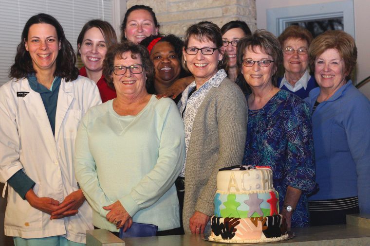 past and present clinic staff group photo with 5 year anniversary cake